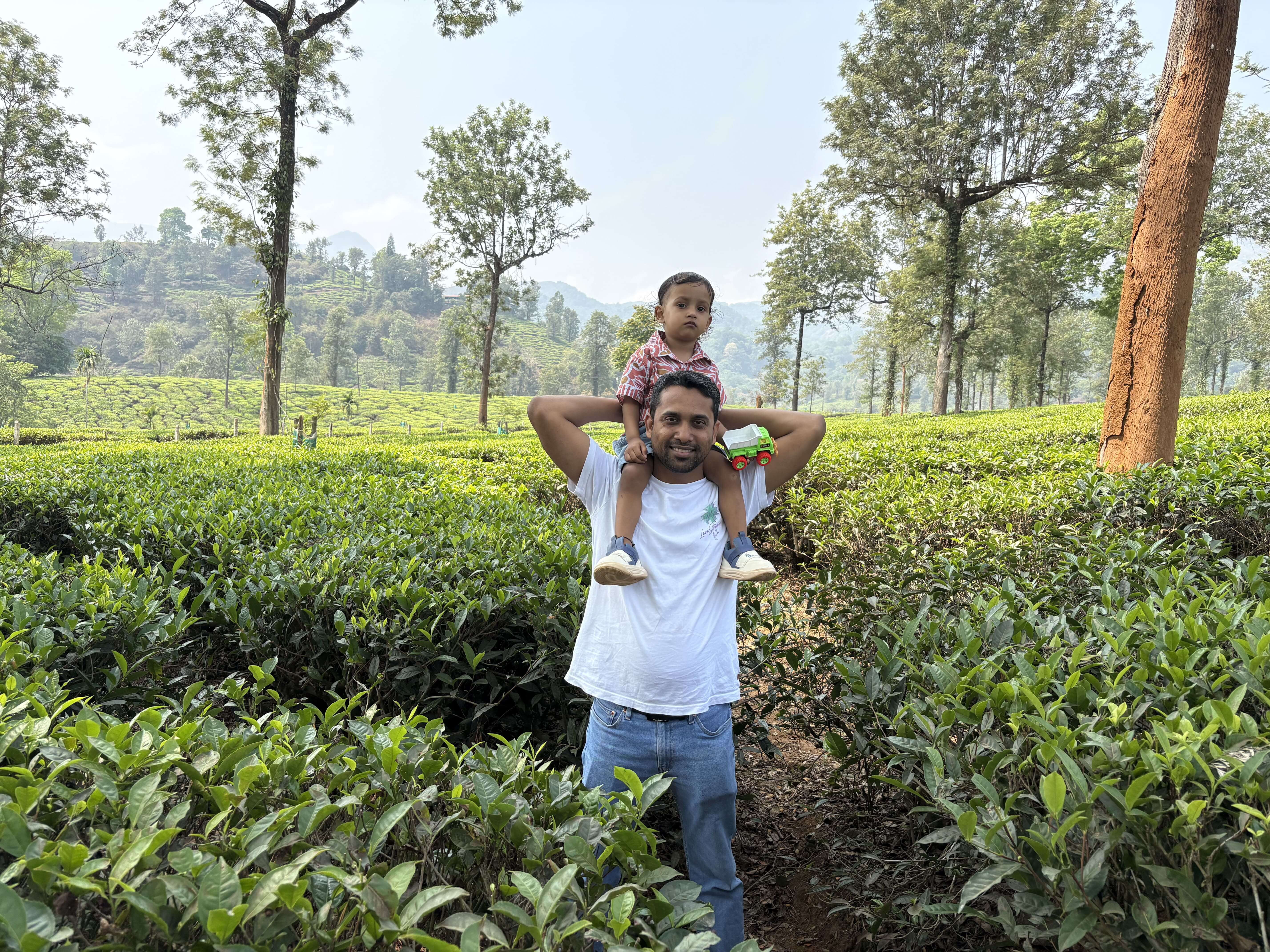 Ravi and his child in a tea garden in Wayanad